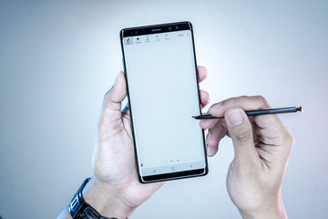Man Holding New Samsung Galaxy Note 8 with S Pen to writing in the blank space.