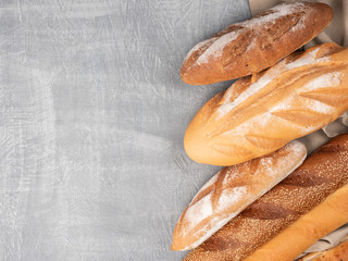 Different types of bread on a concrete surface with a cloth.