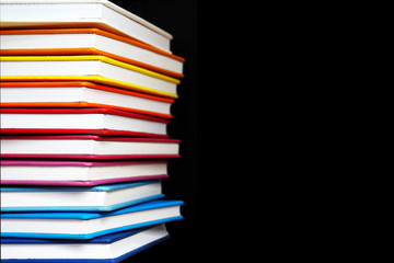Books with Colorful Book Covers Stacked in a Pile, Isolated on Black Background. Bright Education or Business Template with Copy Space