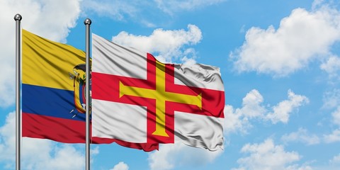 Ecuador and Guernsey flag waving in the wind against white cloudy blue sky together. Diplomacy concept, international relations.