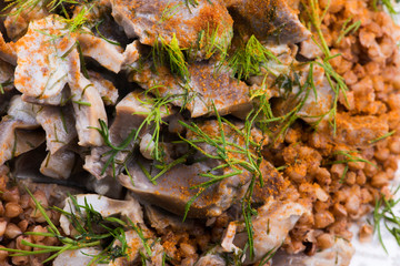Stewed turkey stomachs with vegetables and buckwheat in a bowl