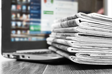 Newspapers and Laptop. Different Concepts for News -  Network or Traditional Tabloid Journals. Data...