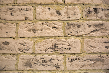 Brick white wall with patches of dark spots