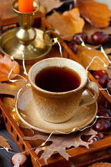 Autumn composition with fall leaves, cup of tea on wooden  tray