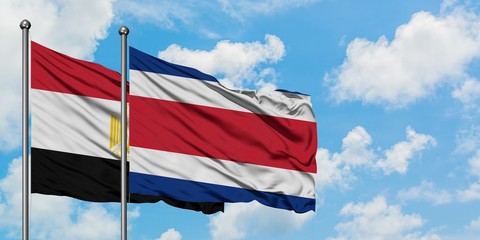 Egypt and Costa Rica flag waving in the wind against white cloudy blue sky together. Diplomacy concept, international relations.