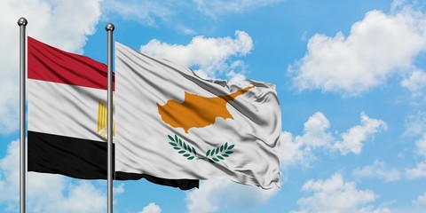 Egypt and Cyprus flag waving in the wind against white cloudy blue sky together. Diplomacy concept, international relations.