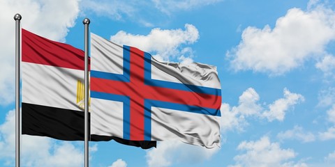 Egypt and Faroe Islands flag waving in the wind against white cloudy blue sky together. Diplomacy concept, international relations.