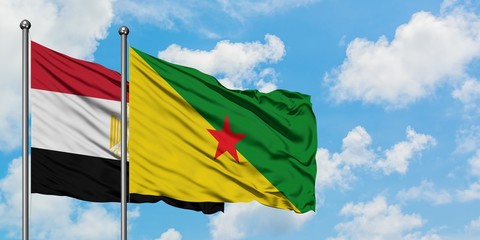Egypt and French Guiana flag waving in the wind against white cloudy blue sky together. Diplomacy concept, international relations.
