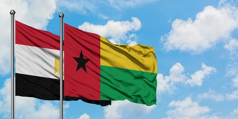 Egypt and Guinea Bissau flag waving in the wind against white cloudy blue sky together. Diplomacy concept, international relations.