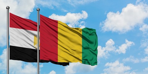 Egypt and Guinea flag waving in the wind against white cloudy blue sky together. Diplomacy concept, international relations.