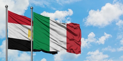 Egypt and Italy flag waving in the wind against white cloudy blue sky together. Diplomacy concept, international relations.