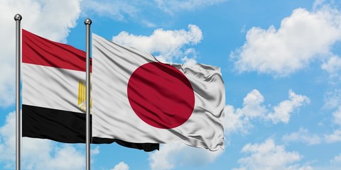 Egypt and Japan flag waving in the wind against white cloudy blue sky together. Diplomacy concept, international relations.