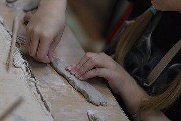 Children's hands sculpts from clay in art school.