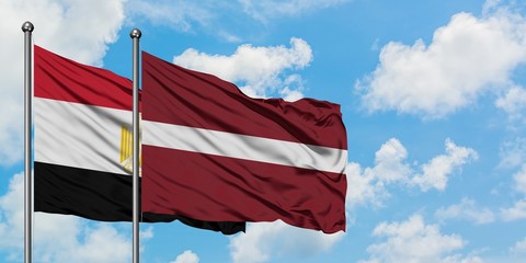 Egypt and Latvia flag waving in the wind against white cloudy blue sky together. Diplomacy concept,...