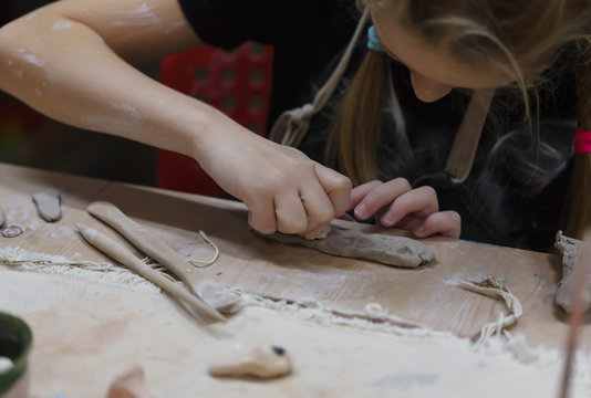 Children's hands sculpts from clay in art school.