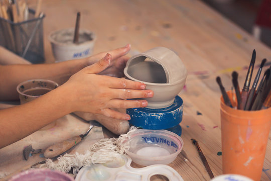 Children's hands sculpts from clay in art school.