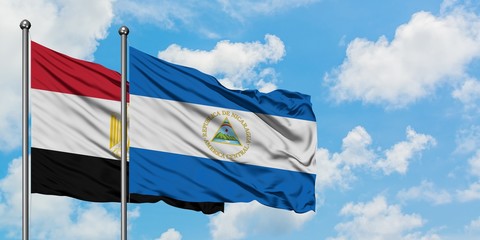 Egypt and Nicaragua flag waving in the wind against white cloudy blue sky together. Diplomacy concept, international relations.