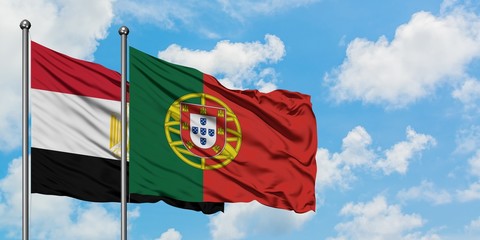 Egypt and Portugal flag waving in the wind against white cloudy blue sky together. Diplomacy concept, international relations.