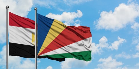 Egypt and Seychelles flag waving in the wind against white cloudy blue sky together. Diplomacy concept, international relations.