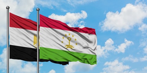 Egypt and Tajikistan flag waving in the wind against white cloudy blue sky together. Diplomacy concept, international relations.