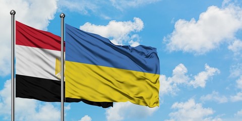 Egypt and Ukraine flag waving in the wind against white cloudy blue sky together. Diplomacy concept, international relations.