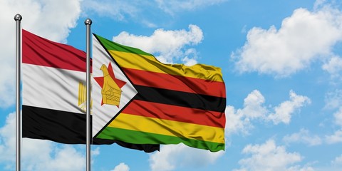 Egypt and Zimbabwe flag waving in the wind against white cloudy blue sky together. Diplomacy concept, international relations.