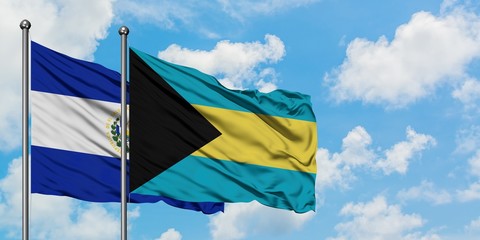 El Salvador and Bahamas flag waving in the wind against white cloudy blue sky together. Diplomacy concept, international relations.