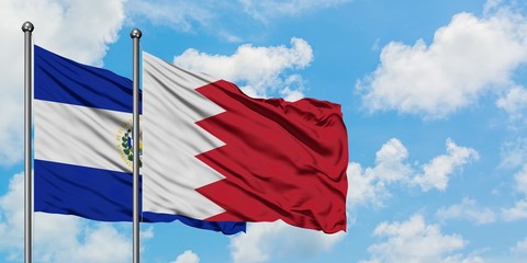 El Salvador and Bahrain flag waving in the wind against white cloudy blue sky together. Diplomacy concept, international relations.