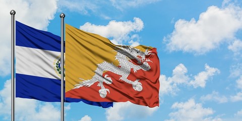 El Salvador and Bhutan flag waving in the wind against white cloudy blue sky together. Diplomacy concept, international relations.