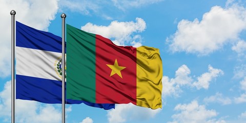 El Salvador and Cameroon flag waving in the wind against white cloudy blue sky together. Diplomacy concept, international relations.