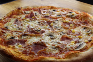 Calabrian pizza with ham, mushroom and cheese on a white plate.