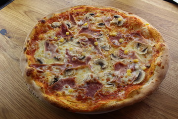 Calabrian pizza with ham, mushroom and cheese on a white plate.