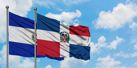 El Salvador and Dominican Republic flag waving in the wind against white cloudy blue sky together. Diplomacy concept, international relations.