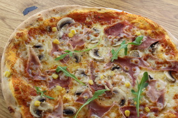 Calabrian pizza with ham, mushroom and cheese on a white plate.