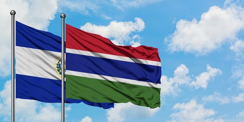 El Salvador and Gambia flag waving in the wind against white cloudy blue sky together. Diplomacy concept, international relations.
