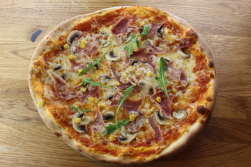 Calabrian pizza with ham, mushroom and cheese on a white plate.