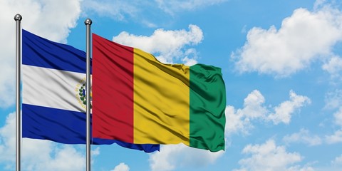 El Salvador and Guinea flag waving in the wind against white cloudy blue sky together. Diplomacy concept, international relations.