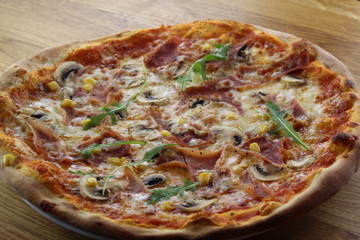 Calabrian pizza with ham, mushroom and cheese on a white plate.
