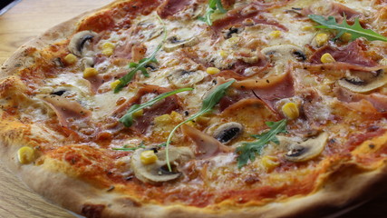 Calabrian pizza with ham, mushroom and cheese on a white plate.