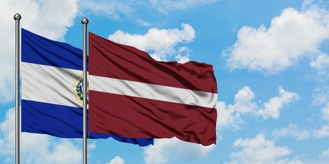 El Salvador and Latvia flag waving in the wind against white cloudy blue sky together. Diplomacy concept, international relations.
