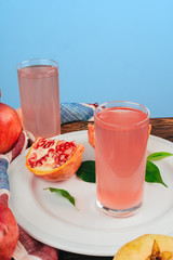Glass of pomegranate juice and fruits on a table