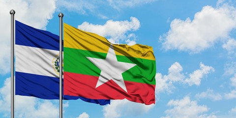El Salvador and Myanmar flag waving in the wind against white cloudy blue sky together. Diplomacy concept, international relations.