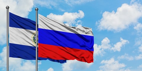 El Salvador and Russia flag waving in the wind against white cloudy blue sky together. Diplomacy concept, international relations.