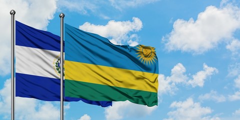 El Salvador and Rwanda flag waving in the wind against white cloudy blue sky together. Diplomacy concept, international relations.