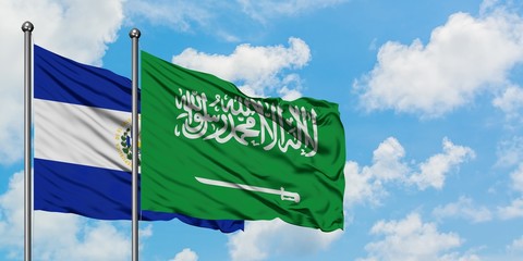 El Salvador and Saudi Arabia flag waving in the wind against white cloudy blue sky together. Diplomacy concept, international relations.