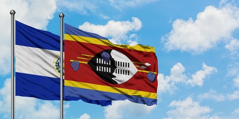 El Salvador and Swaziland flag waving in the wind against white cloudy blue sky together. Diplomacy concept, international relations.