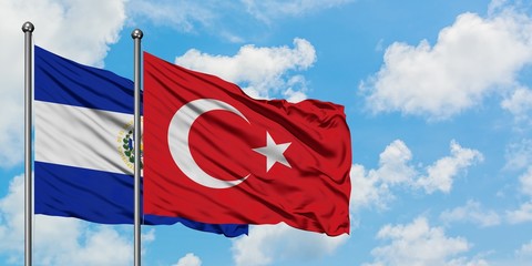 El Salvador and Turkey flag waving in the wind against white cloudy blue sky together. Diplomacy concept, international relations.