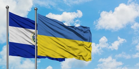 El Salvador and Ukraine flag waving in the wind against white cloudy blue sky together. Diplomacy concept, international relations.