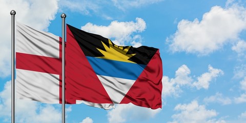 England and Antigua and Barbuda flag waving in the wind against white cloudy blue sky together. Diplomacy concept, international relations.