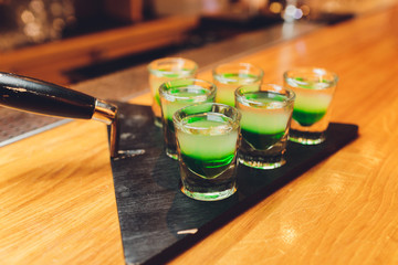 Barman make alcoholic shots with rum and liquor.